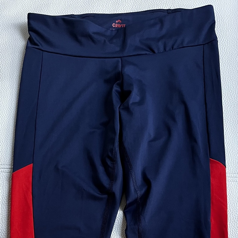 Siniset Crivit legginssit punaisin sivupaneelein ja pienellä heijastimella. 
Alaselän puolella vyötärönauhassa pieni puhelintasku.
Koko S (36/38).